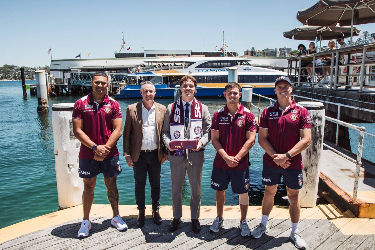 Manly Warringah Sea Eagles players stand with MFF staff at Manly Wharf